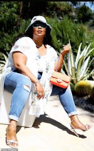 Lizzo in denim and kimono with an orange mini bag