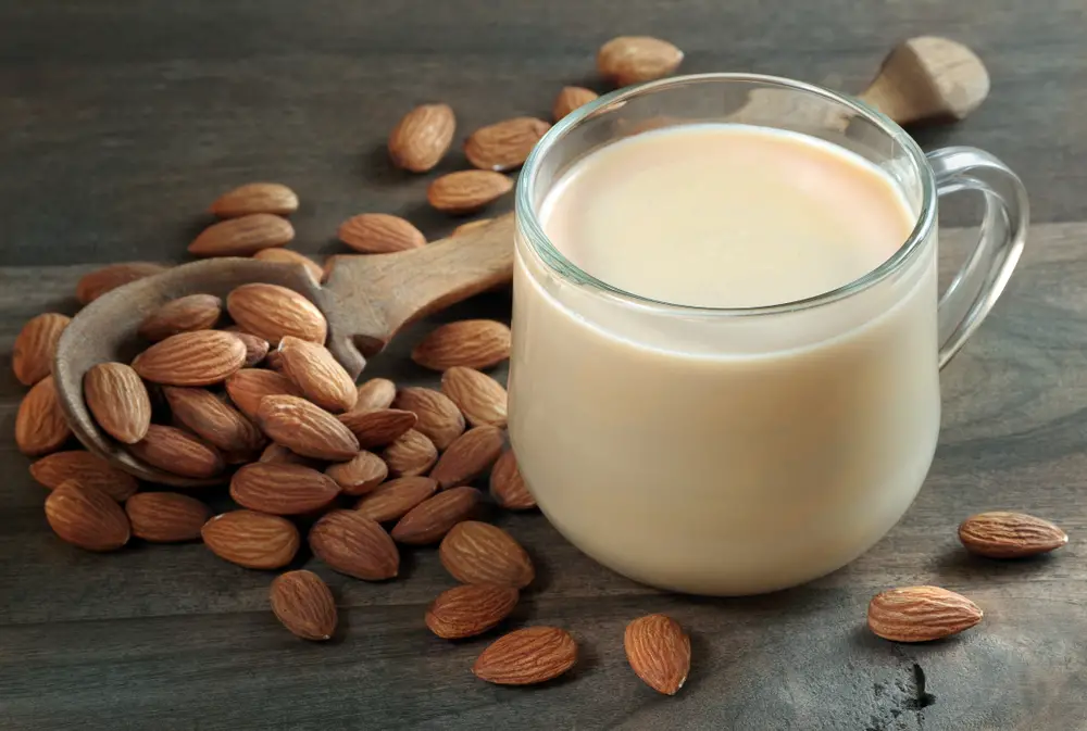 Almond,Milk,In,A,Glass,Cup,On,A,Wooden,Table.